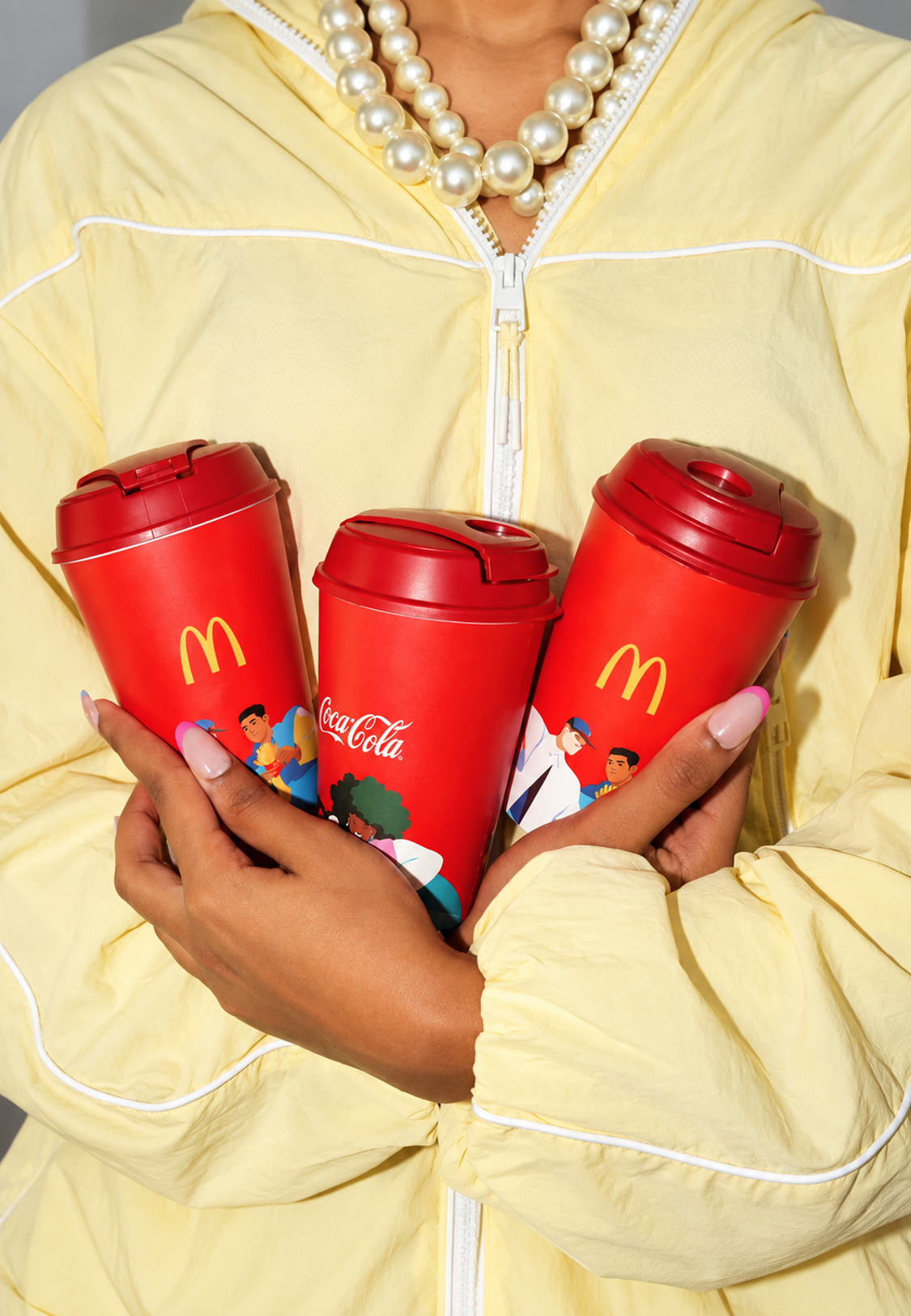 Three colourful branded ChirpyCups held against a pale yellow outfit